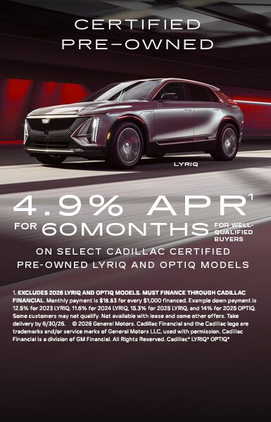 A multi-vehicle lineup of the Cadillac VISTIQ, LYRIQ, and OPTIQ parked on a paved stone driveway in front of a sunset