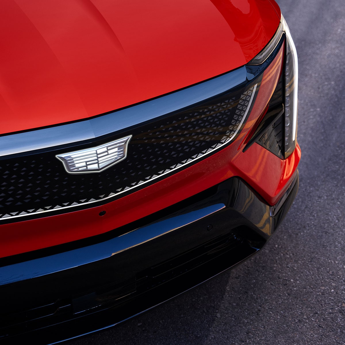 Close Up of a Red Cadillac OPTIQ Grill and Left Headlight