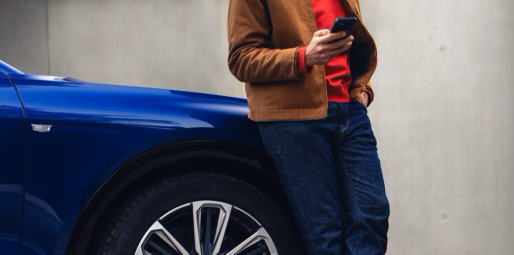 Man on mobile phone with Cadillac LYRIQ